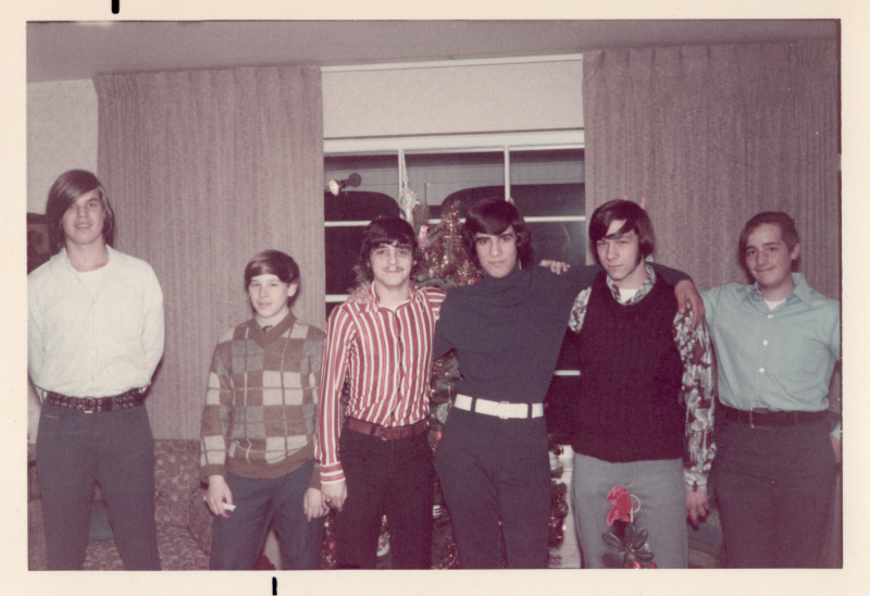 Six men pose in front of a Christmas tree