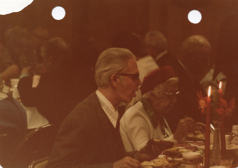 An older man and woman eat together