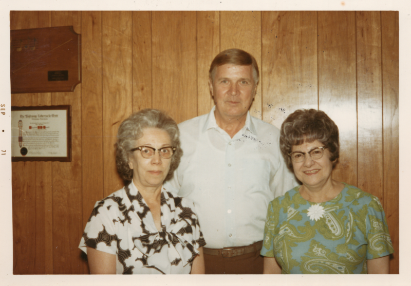 A man and two women smile together