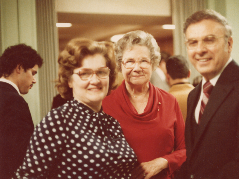 Pastor and Mrs. Bogdan smile with a woman