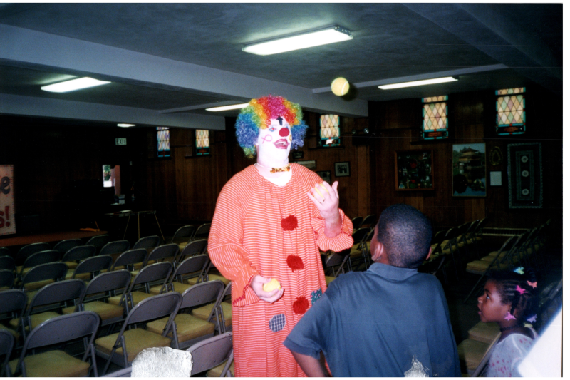 Dressed as a clown, Johnny juggles for two children