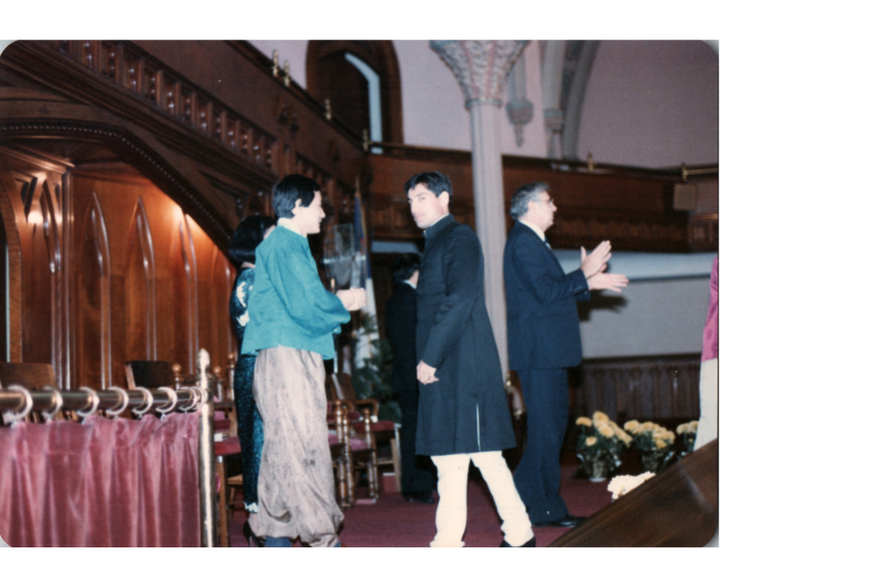 A group of people on stage in the sanctuary, including Pastor Bogdan, lead a service