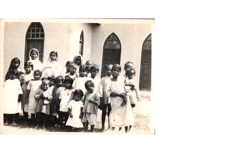 Several young children pose together. Caption: "Here are some of our orphan children. The Lord is enlargening this end of the work and has sent us during the last two months five more girls. Please pray for them all."