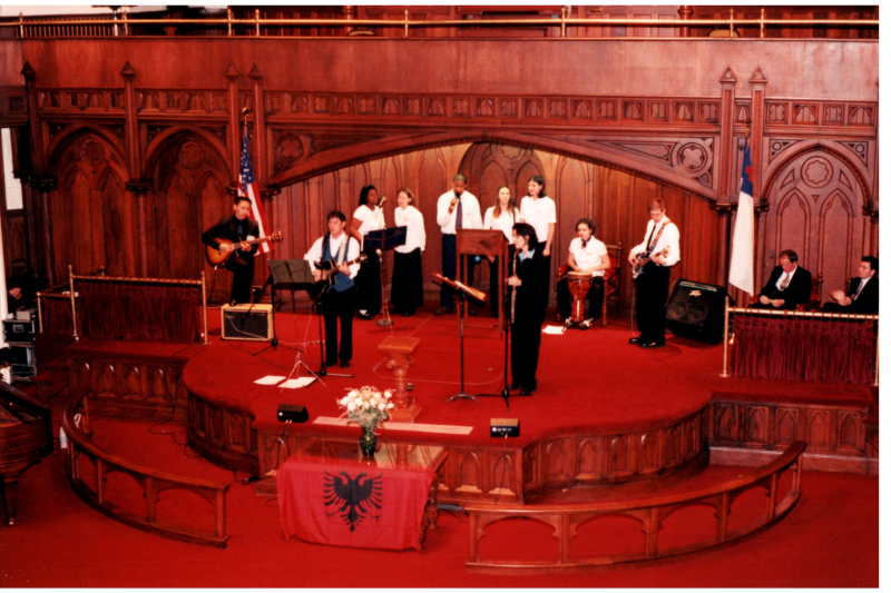 Music performance in front of an Albanian flag in the sanctuary