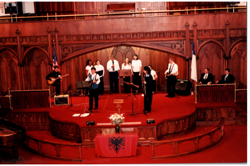 Music performance in front of an Albanian flag in the sanctuary