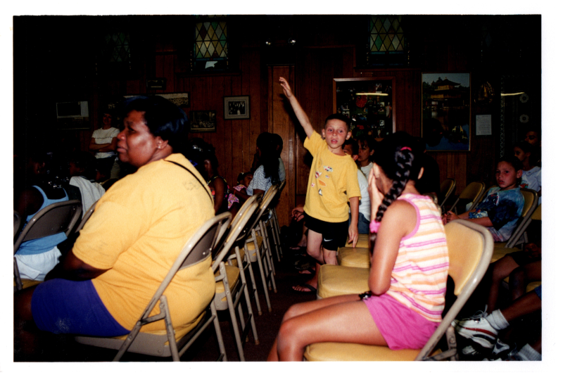A boy raises his hand