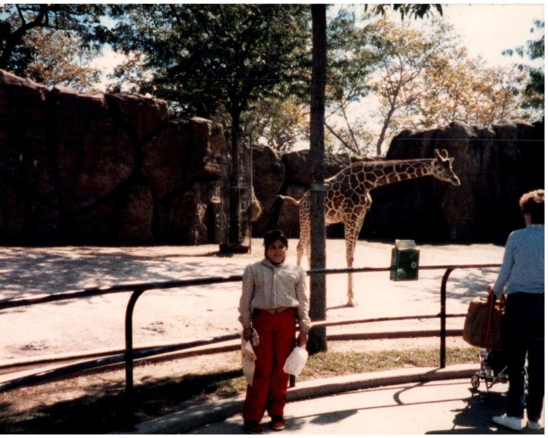 A woman poses with a giraffe